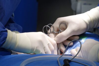 Close-up of surgeons' hands in surgical gloves performing an operation in a hospital operating room under sterile conditions.