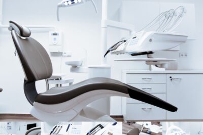 A modern dental clinic interior showcasing a dental chair and equipment in a clean, clinical setting.