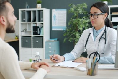 A doctor and patient engaged in consultation in a modern clinic office.